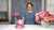 Instructor behind a pink clay peony bouquet and a white lattice vase filled with pink and peach peonies.