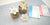 White clay gardenia flowers in woven containers beside DECO Flower Course 1 and Tropical Course 1 curriculum books.