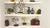 Three clay wisteria bonsai trees with cascading purple and white flowers, displayed in shallow pots on white shelves.