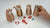 Four handcrafted clay tiger figures with orange and brown stripes, displayed with small colorful Japanese New Year ornaments.⠋